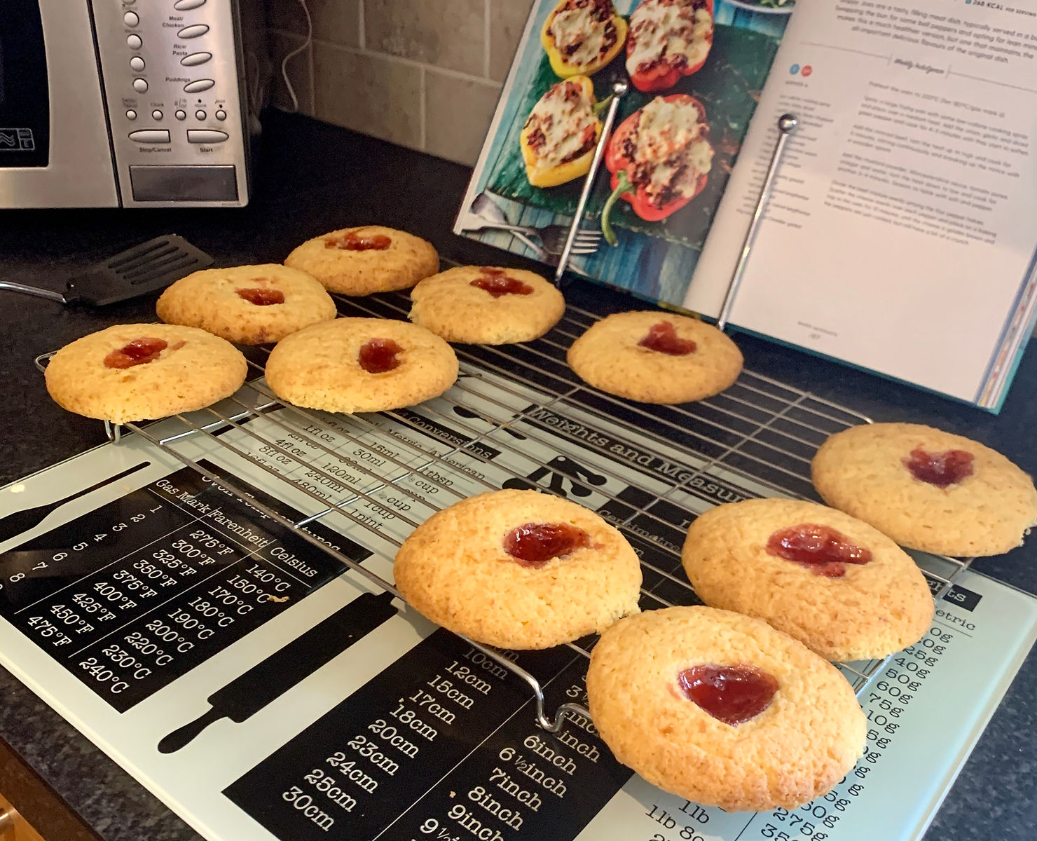 Jam & coconut biscuits spread out on a cooling tray in Ross's kitchen
