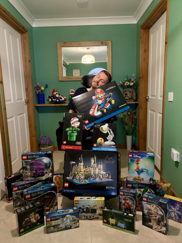 Ross sat in his hallway surrounded by a mountain of Lego boxes on his lap and the surrounding floor.