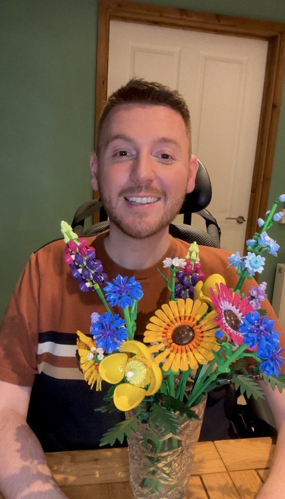 Ross smiling with a LEGO flower bouquet